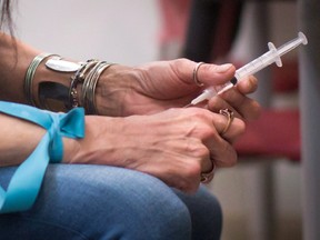 A person injects an opioid at a Vancouver clinic.