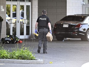 An Ottawa Police officer collects evidence after a Saturday night shooting at the Infinity Convention Centre that left two dead, in Ottawa, on Sunday, Sept. 3, 2023.