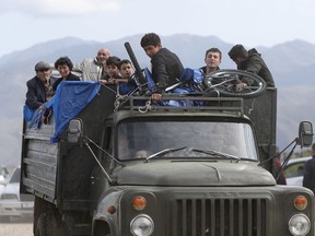 FILE - Ethnic Armenians from Nagorno-Karabakh ride a truck on their way to Kornidzor in Syunik region, Armenia, Sept. 26, 2023. Thousands of Nagorno-Karabakh residents are fleeing their homes after Azerbaijan's swift military operation to reclaim control of the breakaway region after a three-decade separatist conflict.