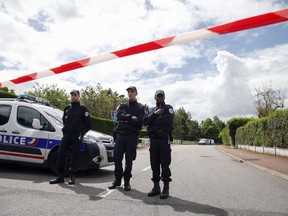 FILE - French police officers block the road leading to a crime scene the day after a knife-wielding attacker stabbed to death a senior police officer and his female companion Monday evening in Magnanville, west of Paris, France, Tuesday, June 14, 2016. A trial is opening in French counterterrorism court Monday Sept. 25, 2023 over the killing of two police officers in their home in 2016, in front of their 3-year-old son.