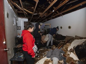 File - Jorge Amezquita, from right, cousin Adalene Castillo and girlfriend Cassandra Duarte look for a TV remote under debris after a tornado ripped the roof off the apartment, Tuesday, Jan. 24, 2023, at Beamer Place Apartments in Houston. When natural or manmade disasters happen, renters insurance can mean the difference between catastrophe and stability.