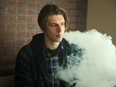 A teen boy vaping.