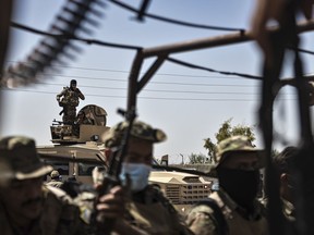 U.S.-backed Syrian Democratic Forces (SDF) fighters sit on their armored vehicles, at al-Sabha town in the eastern countryside of Deir el-Zour, Syria, Monday, Sept. 4, 2023. Weeklong clashes between rival U.S.-backed militias in eastern Syria, where hundreds of American troops are deployed, point to dangerous seams in a coalition that has kept on a lid on the defeated Islamic State group for years.
