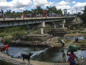 FILE - People bathe in the Massacre River, named for a bloody battle between Spanish and French colonizers in the 1700s, on the border with Haiti in Ouanaminthe, Dominican Republic, Nov. 19, 2021. The Dominican Republic's President Luis Abinader announced on Sept. 11, 2023 he has suspended issuing visas to Haitians.