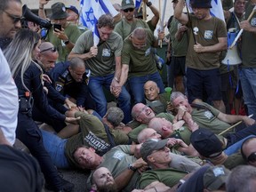 Israeli police disperse demonstrators, mostly military reservists, who block a road outside the house of Israeli Justice Minister Yariv Levin during a protest against plans by Prime Minister Benjamin Netanyahu's government to overhaul the judicial system, in Modiin, Israel, Monday, Sept. 11, 2023.
