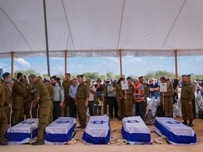 Mourners gather around the five coffins of the Kotz family during their funeral in Gan Yavne, Israel, Tuesday, Oct. 17, 2023. The family was killed by Hamas militants on Oct. 7 at their house in Kibbutz Kfar Azza near the border with the Gaza Strip.