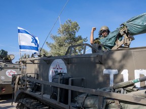 IDF soldiers ride in armoured personnel carriers