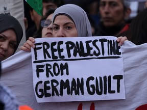 A woman holds a sign that reads: "Free Palestine from German guilt" in reference to Germany's unequivocal support for Israel during a pro-Palestinian on Oct. 28, 2023 in Berlin.