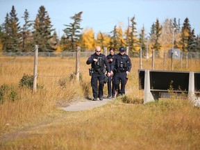 Calgary police search on 68 Street S.E. near Applewood Drive in Calgary on Tuesday, October 3, 2023. An officer came upon a large amount of money and people on the side of the street picking up large amounts of cash. There are no initial reports of where the cash was from or where it belonged.