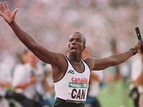 Donovan Bailey raises his arms after crossing the finish line to win the Olympic gold medal in the men's 4x100 metre relay final with a time of 37.69 at the Summer Olympic Games August 3rd in Atlanta. (CP PHOTO) 1996