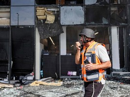 A member of emergency personnel inspects the damage at a supermarket after it was hit by an incoming rocket in the southern Israeli city of Ashkelon on October 11, 2023.
