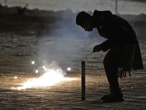 n Edmonton man lights fireworks during a celebration of Diwali at the Bhartiya Cultural Centre in Edmonton.