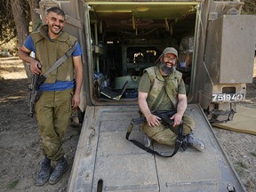Two Israeli soldiers smile near the Gaza Strip.