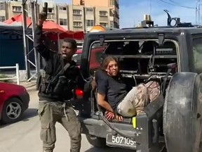 A Hamas fighter shouts "Allah Akbar" before hauling a kidnapped and bleeding Israeli woman from a truck and then shoving her back as other men cheer, in a still taken from a video.