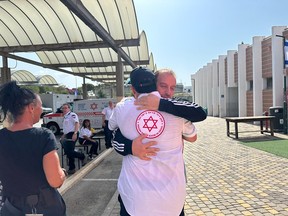 A Canadian doctor and the father of a patient embrace in Israel.