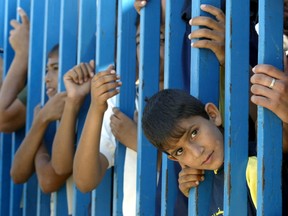 Palestinian children protest with adults (unseen) at the gates of the border crossing against the closure of the Rafah border with Egypt in the southern Gaza Strip, July 10, 2007.