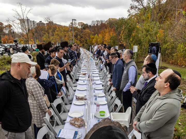  People take part in prayer after the setting of a Shabbat table in Toronto for the 200 Israeli hostages held by Hamas, Friday, Oct. 27.