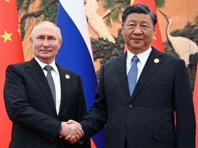Russian President Vladimir Putin and Chinese President Xi Jinping shake hands during a meeting in Beijing on Oct. 18, 2023.
