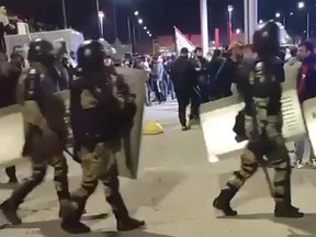 Riot police march past protesters at an airport in Makhachkala.