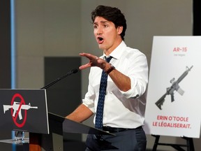 Liberal Leader Justin Trudeau speaks with gun control signs around him.