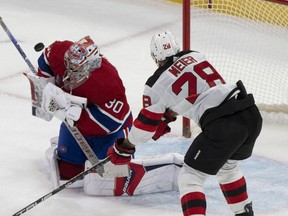 Montreal Canadiens goaltender Cayden Primeau (30) makes a save as New Jersey Devils' Timo Meier (28) looks on during first period NHL hockey action in Montreal on Tuesday, Oct. 24, 2023.