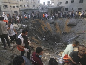 Palestinians look for survivors after an Israeli strike on the Zaroub family house in Rafah, Gaza Strip, Tuesday, Oct. 24, 2023.