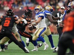 Winnipeg Blue Bombers quarterback Zach Collaros, centre, looks for an open receiver before throwing an incomplete pass during the first half of a CFL football game against the B.C. Lions, in Vancouver, on Friday, October 6, 2023.