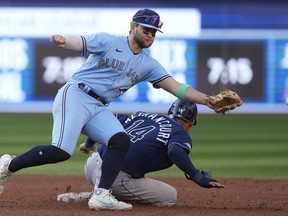 Tampa Bay Rays catcher Christian Bethancourt (14) is safe at third base after Toronto Blue Jays shortstop Bo Bichette (11) can't get to the throw during sixth inning American League MLB baseball action in Toronto, Saturday, Sept. 30, 2023.