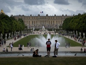 FILE - Visitors enjoy the Chateau de Versailles gardens, outside Paris, France, on July 15, 2023. The Louvre Museum in Paris and Versailles Palace evacuated visitors and staff Saturday, Oct. 14, 2023 after receiving bomb threats. The government has put France on high security alert after a fatal school stabbing by a suspected extremist.