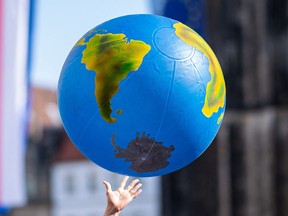 A student reaches for an inflated globe during a climate protest in Muenster, northwestern Germany, in 2019.
