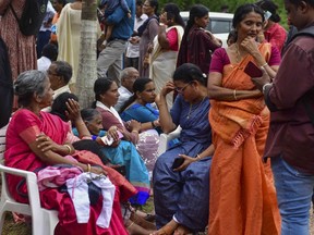 Jehovah's Witness faithful and others wait outside the Zamra International Convention Center after an explosive device blew up during their prayer session in Kalamassery, a town in Kochi, southern Kerala state, India, Sunday, Oct.29, 2023. At least one person died and 36 others were injured in the explosion, authorities said. (AP Photo)