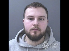 This undated handout photo provided by South Wales Police shows Lewis Edwards. Edwards, a former British police officer, has been sentenced to life in prison with a minimum term of 12 years after he pleaded guilty to over 100 child sex offenses. The crimes included threatening and blackmailing more than 200 young girls into sending him sexual photos of themselves on Snapchat. (South Wales Police via AP)