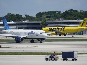 FILE - A JetBlue Airways Airbus A320, left, passes a Spirit Airlines Airbus A320 as it taxis on the runway, July 7, 2022, at the Fort Lauderdale-Hollywood International Airport in Fort Lauderdale, Fla. The Biden administration's fight against consolidation in the airline industry will be tested Tuesday, Oct. 31, 2023 with lawyers for JetBlue Airways and the Justice Department due in court.