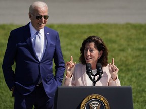 FILE - President Joe Biden looks on as Commerce Secretary Gina Raimondo speaks on the South Lawn of the White House, Aug. 9, 2022, in Washington. The Biden administration is designating 31 "tech hubs" in 32 states and Puerto Rico to help spur innovation and create jobs in the specific industries that are concentrated in these areas. "I have to say, in my entire career in public service, I have never seen as much interest in any initiative than this one," Raimondo told reporters during a Sunday, Oct. 22, 2023, conference call to preview the announcement.