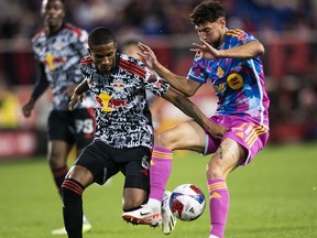 Toronto FC midfielder Jonathan Osorio, right, vies for the ball against New York Red Bulls defender Kyle Duncan during an MLS soccer match Saturday, Oct. 7, 2023, in Harrison, N.J.