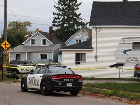 Police tape and vehicles surround a crime scene in Sault Ste. Marie