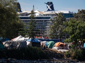 Tents and people are seen at a homeless encampment at Crab Park as the Celebrity Cruises vessel Celebrity Eclipse is docked at port in Vancouver, on August 14, 2022. The British Columbia government says results from the latest surveys of people living on the streets show current support levels aren't enough and more services are needed to address rising homelessness throughout the province. A statement from the Housing Ministry says homelessness counts conducted in 20 B.C. communities over a 24-hour period showed an increase compared with previous counts in 2020 and 2021.THE CANADIAN PRESS/Darryl Dyck