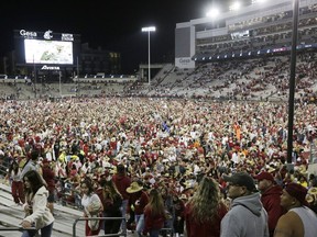 Washington State fans and players celebrate on the field after the team won an NCAA college football game against Oregon State 38-35, Saturday, Sept. 23, 2023, in Pullman, Wash.