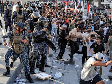 Riot police disperse anti-government protesters in Baghdad on Oct. 1, 2023.