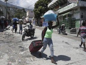 FILE - Residents flee their homes to escape clashes between armed gangs in the Carrefour-Feuilles district of Port-au-Prince, Haiti, Aug. 25, 2023. The United Nations Security Council approved on Oct. 2 the deployment of an international armed force to Haiti.