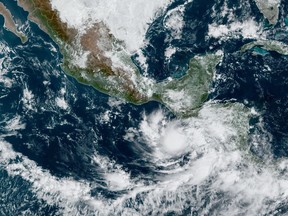 This satellite image provided by NOAA on Monday, Oct. 30, 2023, shows Tropical Storm Pilar approaching El Salvador on the Pacific coast of Central America. (NOAA via AP)
