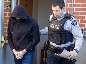 Michael MacKay, left, was escorted out of Battleford provincial court by an RCMP officer after pleading guilty to second-degree murder of his wife Cindy MacKay. Photo taken Monday, Nov. 20, 2023.