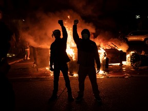 Demonstrators raise their fists as a fire burns in the street after clashes with law enforcement near the Seattle Police Departments East Precinct shortly after midnight on June 8, 2020 in Seattle, Washington.