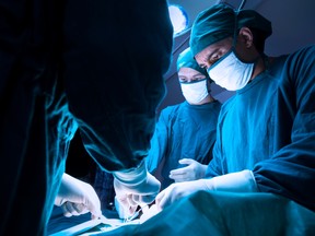 Doctors perform surgery on a patient in the operating room of a hospital.