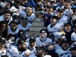 Members of the Montreal Carabins celebrate with the Vanier Cup, Saturday, Nov. 25, 2023 in Kingston, Ont. The Carabins defeated the UBC Thunderbirds 16-9 to win the Canadian University Football Championship.