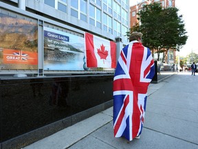 A person draped in a Union Jack passes the British High Commission in Ottawa after the death of Queen Elizabeth II.