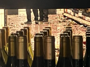 A liquor store floor covered with wine and shattered bottles.