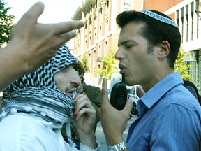 A Muslim man and a Jewish man argue during a protest.