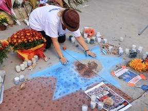 A woman draws a Star of David with chalk around the blood of killed protester Paul Kessler.