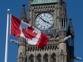 The Canadian flag flies in front of the Peace Tower on Parliament Hill.